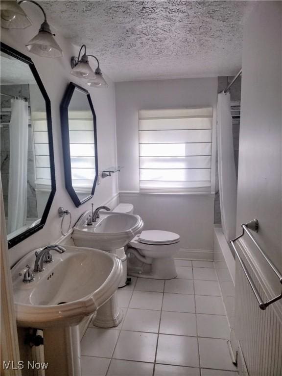 bathroom featuring tile patterned flooring, a healthy amount of sunlight, shower / tub combo, and a textured ceiling