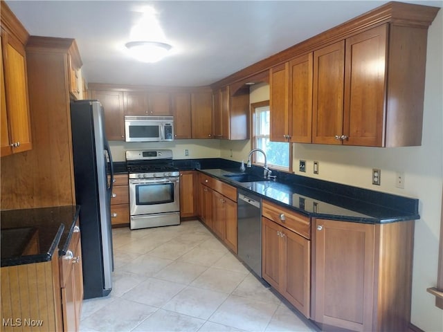 kitchen with appliances with stainless steel finishes, sink, and light tile patterned floors