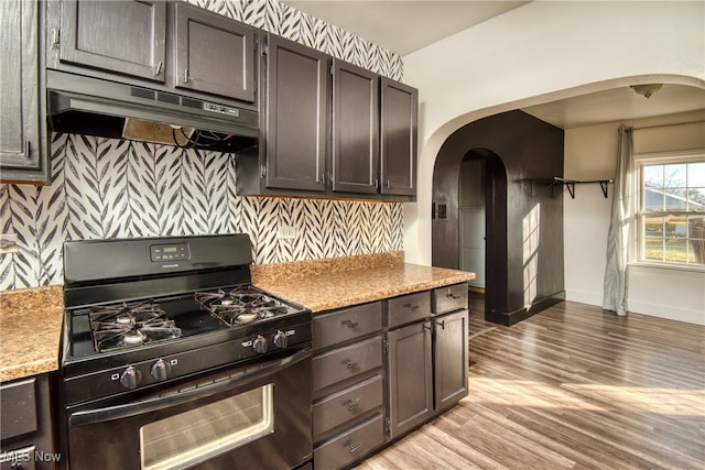 kitchen with dark brown cabinetry, light hardwood / wood-style flooring, and black range with gas cooktop