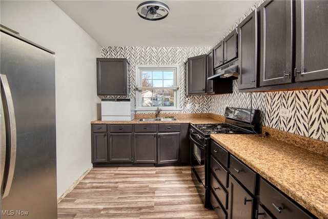 kitchen with sink, light hardwood / wood-style floors, dark brown cabinets, gas stove, and stainless steel refrigerator