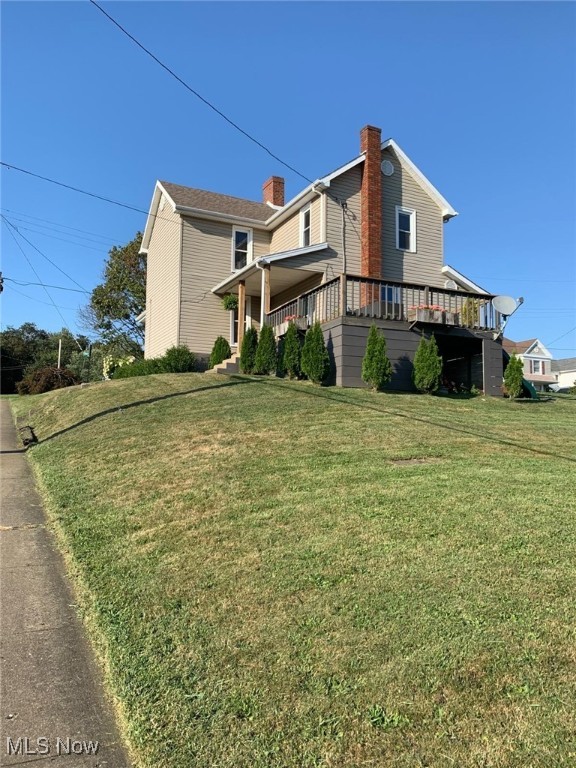 view of side of property featuring a lawn and a porch