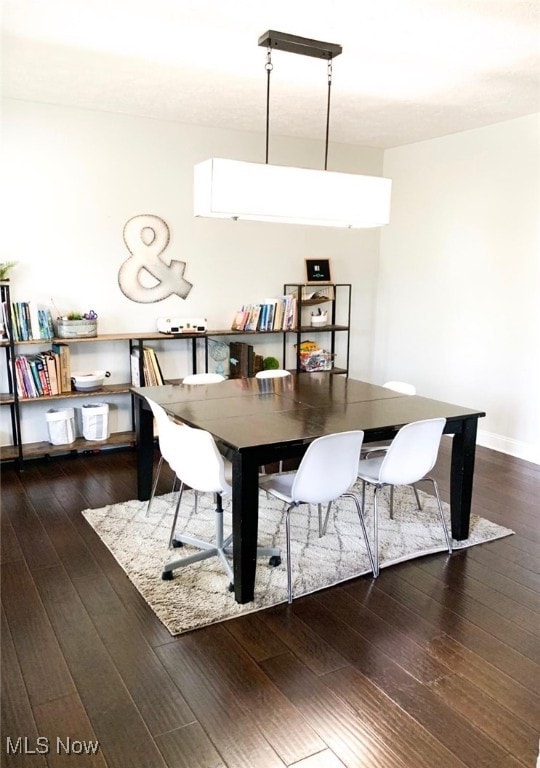 dining space with dark wood-type flooring