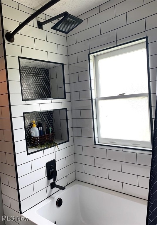 bathroom with tiled shower / bath and plenty of natural light