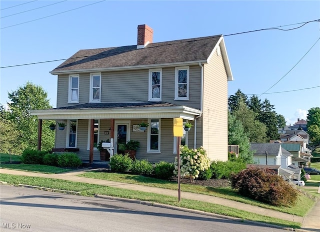 view of front of home with a front yard and a porch