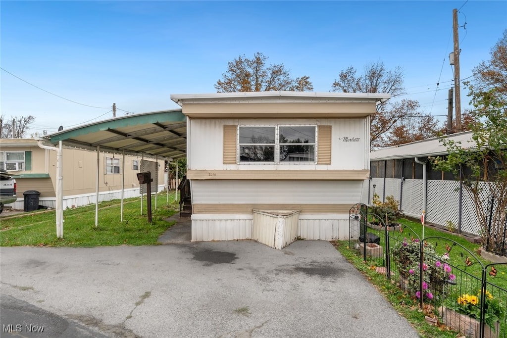 view of front of home with a carport and a front yard