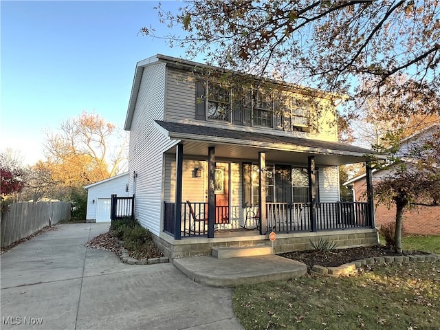 view of front of property with covered porch, a garage, and an outdoor structure