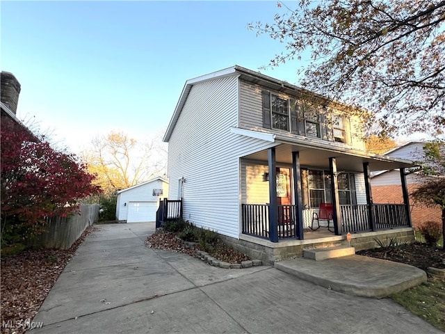 view of front property with covered porch, a garage, and an outdoor structure