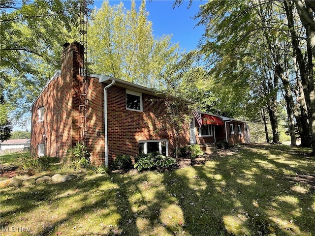 view of side of home with a lawn