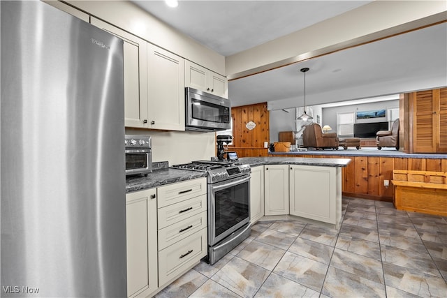 kitchen featuring white cabinetry, hanging light fixtures, stainless steel appliances, kitchen peninsula, and dark stone countertops