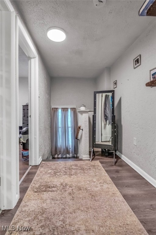 foyer entrance with dark hardwood / wood-style flooring and a textured ceiling