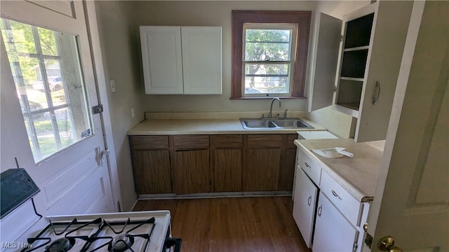 kitchen featuring white cabinets, sink, white range with gas cooktop, and dark wood-type flooring