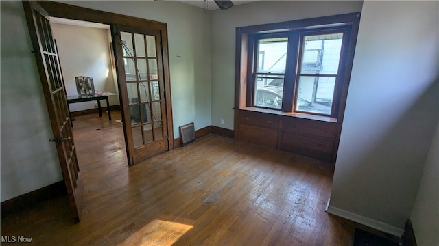 empty room featuring ceiling fan, french doors, and hardwood / wood-style flooring