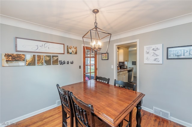 dining area featuring a notable chandelier, crown molding, and light hardwood / wood-style flooring