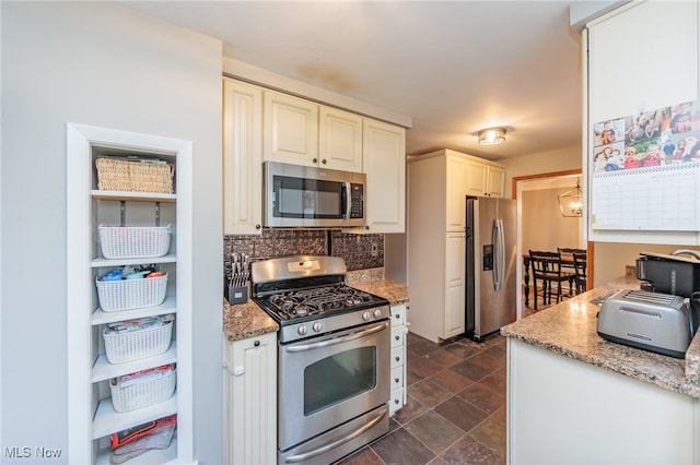 kitchen with light stone counters, white cabinets, and appliances with stainless steel finishes