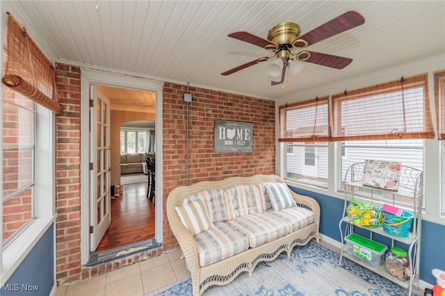 sunroom featuring ceiling fan and wood ceiling