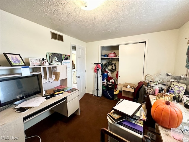 home office with dark carpet and a textured ceiling