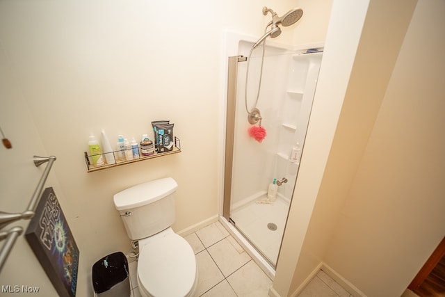 bathroom featuring tile patterned flooring, toilet, and walk in shower