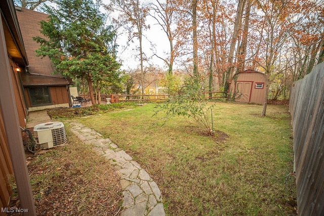 view of yard featuring a storage unit and central AC