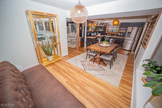 dining room featuring wood-type flooring and indoor bar