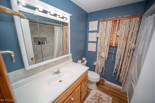 bathroom with vanity, hardwood / wood-style flooring, toilet, and curtained shower