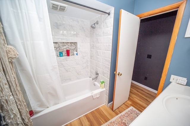 bathroom with sink, wood-type flooring, and shower / tub combo