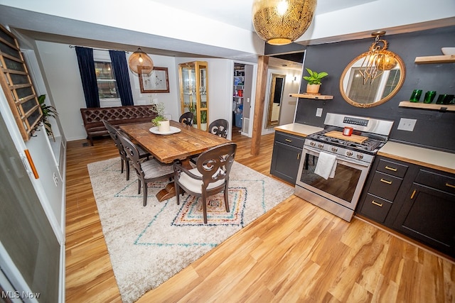 kitchen with gas stove, light hardwood / wood-style floors, and hanging light fixtures