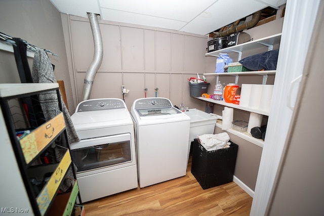 laundry area with independent washer and dryer and light wood-type flooring