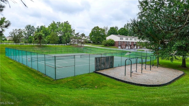 view of community featuring a lawn and tennis court