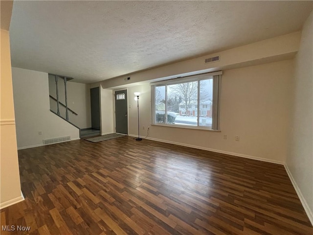 empty room featuring a textured ceiling and dark hardwood / wood-style floors