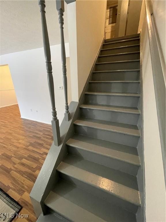 staircase with hardwood / wood-style floors