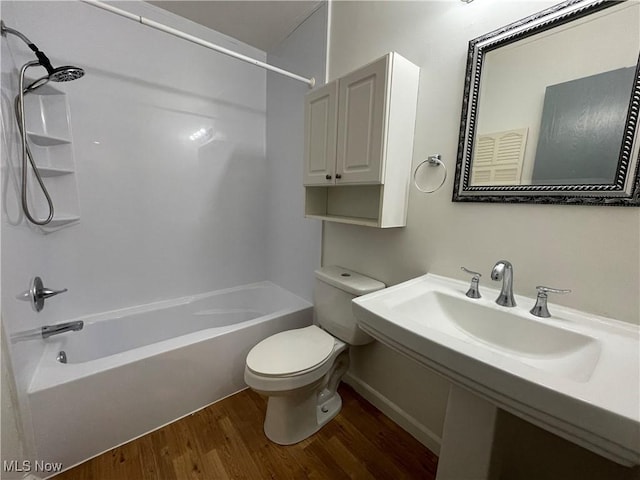 full bathroom featuring hardwood / wood-style floors, toilet, tub / shower combination, and sink