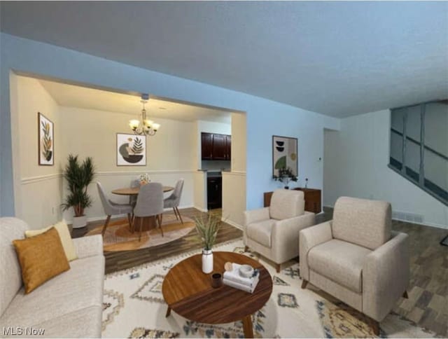 living room featuring hardwood / wood-style flooring and an inviting chandelier