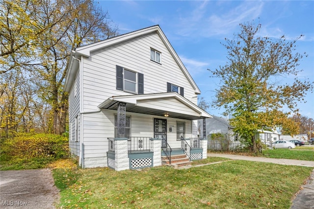 view of property featuring covered porch and a front lawn