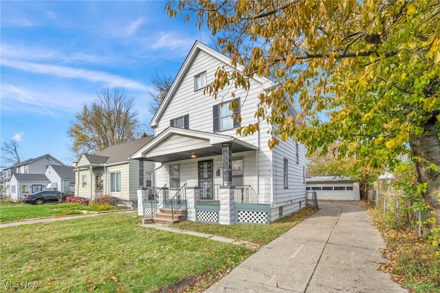 view of front property featuring covered porch, a garage, a front lawn, and an outdoor structure