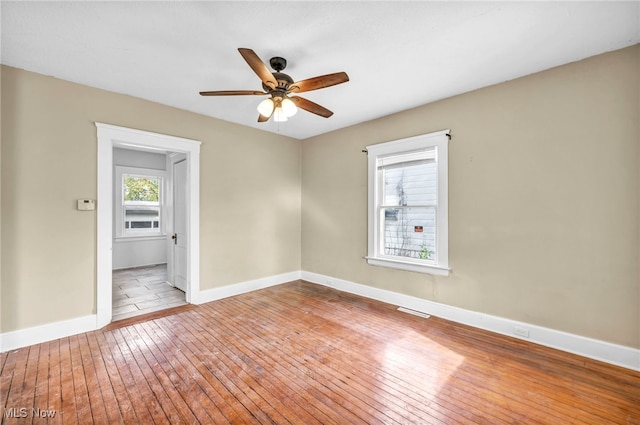 empty room with ceiling fan and light wood-type flooring