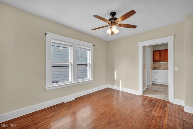 unfurnished room with ceiling fan and light hardwood / wood-style flooring