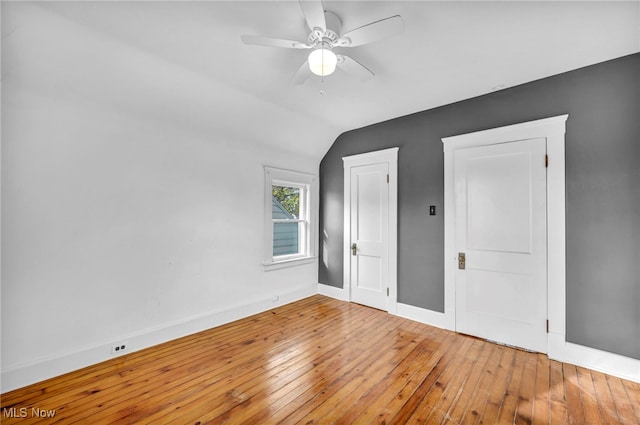 unfurnished bedroom featuring hardwood / wood-style flooring, vaulted ceiling, and ceiling fan