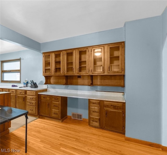 kitchen with light hardwood / wood-style floors and built in desk