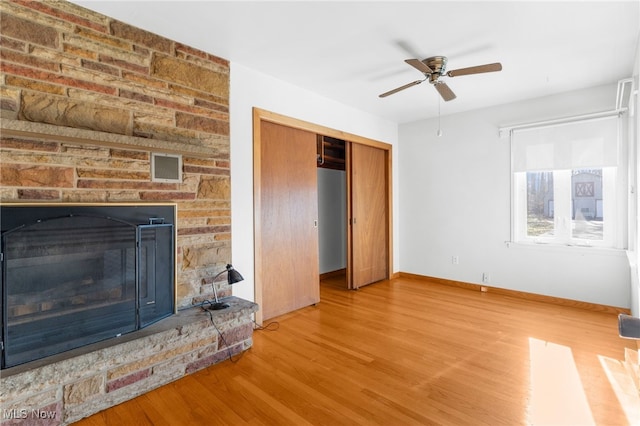 living room with hardwood / wood-style floors, ceiling fan, and a fireplace