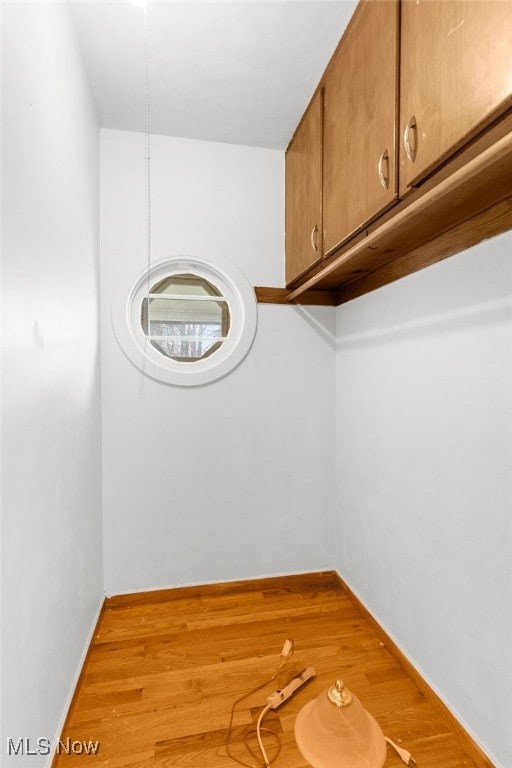 laundry area with light wood-type flooring