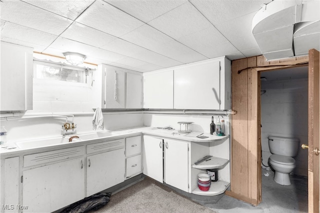 bathroom with vanity, toilet, concrete flooring, and wooden walls