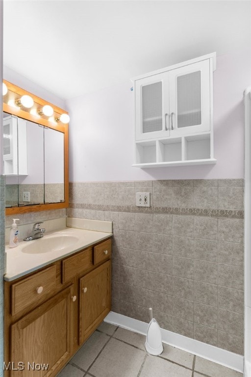 bathroom with tile patterned flooring, vanity, and tile walls