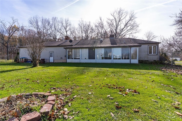 back of house with a lawn and a sunroom