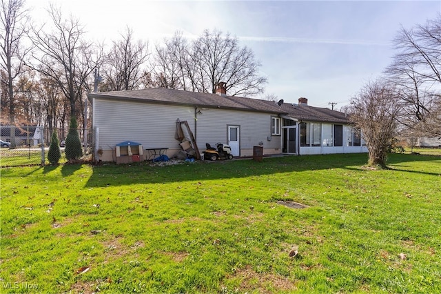 back of house with a sunroom and a yard