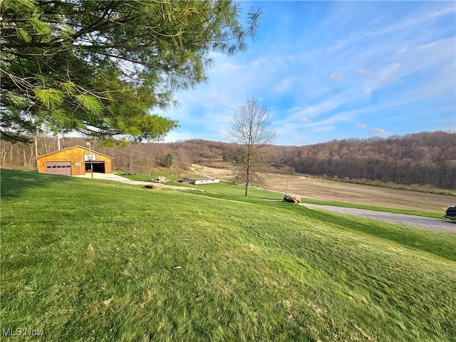 view of yard with an outbuilding, a rural view, and a garage