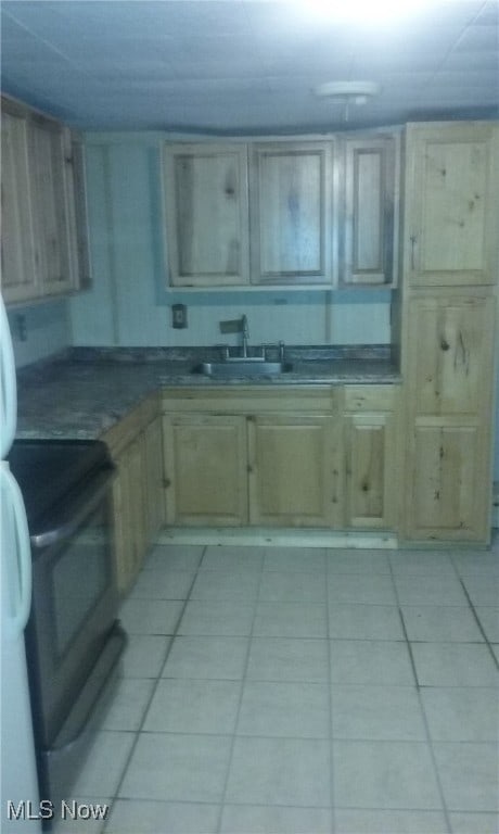 kitchen featuring black electric range, light tile patterned floors, and sink