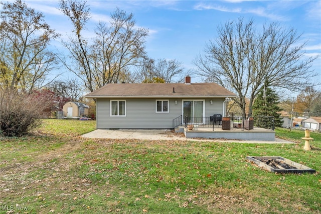 back of house with a yard, a patio, and a shed