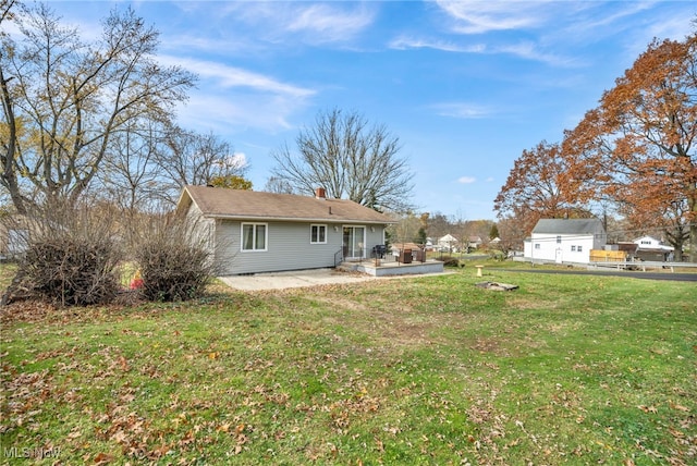 back of house featuring a lawn and a patio