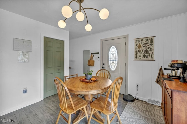 dining room featuring light wood-type flooring, an inviting chandelier, and ornamental molding