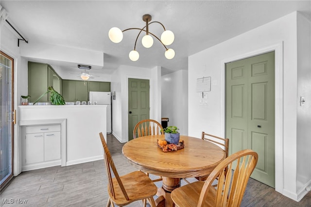 dining room with hardwood / wood-style floors and an inviting chandelier